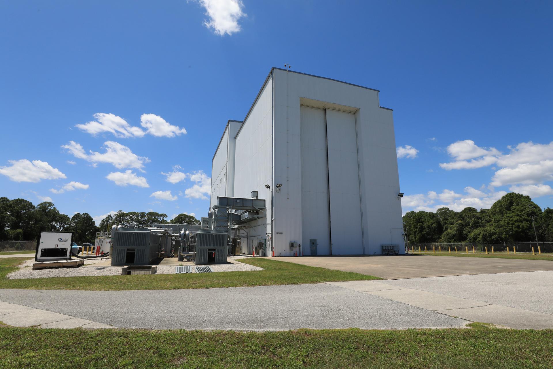 Image shows sunny, blue skies with a few wispy clouds outside the NASA Kennedy’s Payload Hazard...