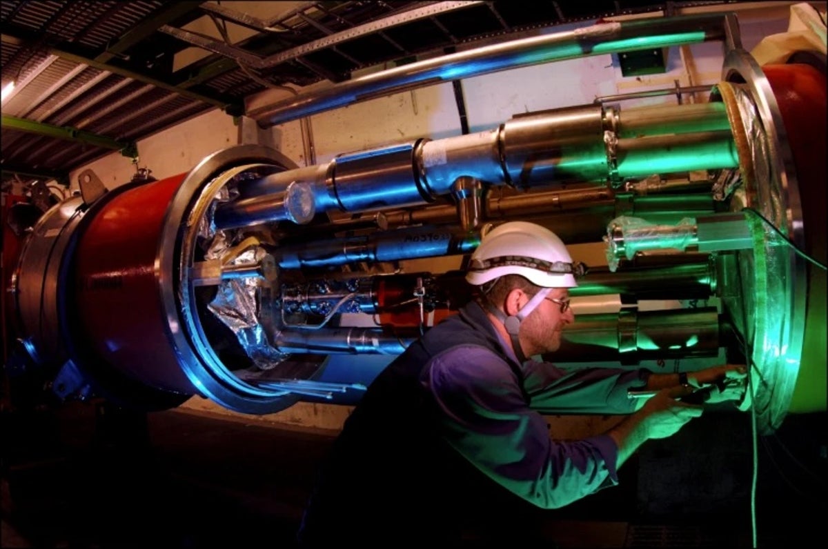 engineer-LHCb-experiment An engineer works on equipment for the LHCb experiment inside the tunnel of the Large Hadron Coll...