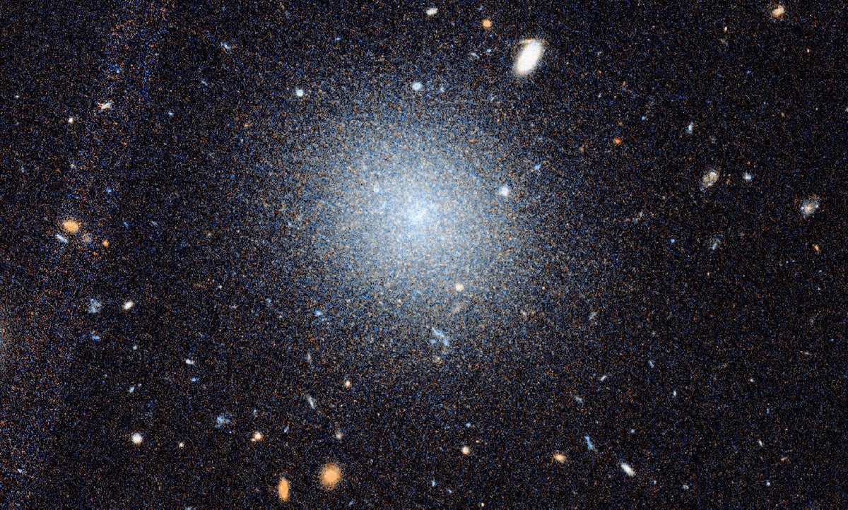 D9 A close-up Hubble image of the galaxy DF9 is shown beneath a wider view of the surrounding NGC 10...