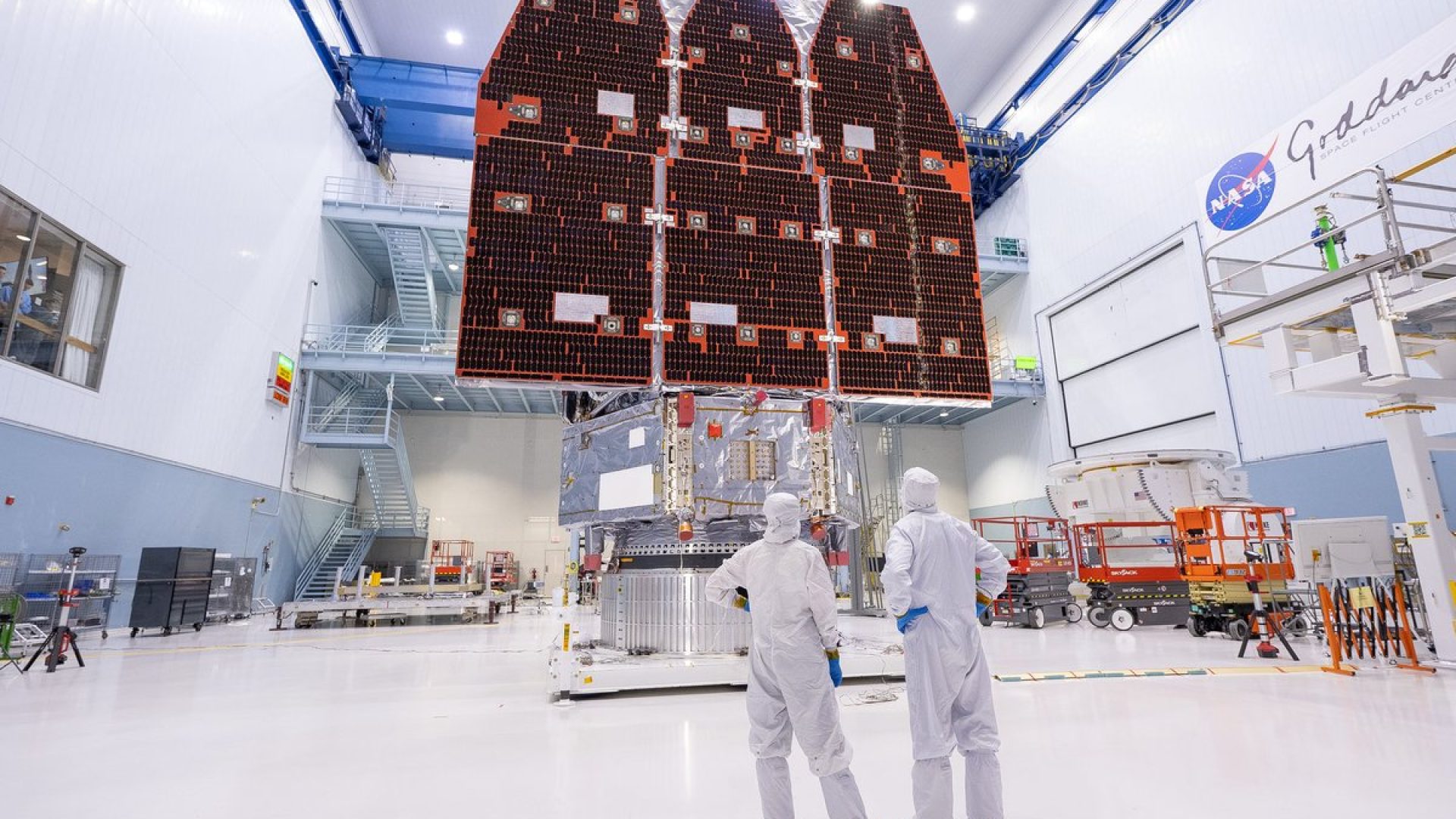 In a clean room at at NASA’s Goddard Space Flight Center, technicians view the Goddard-built $4...