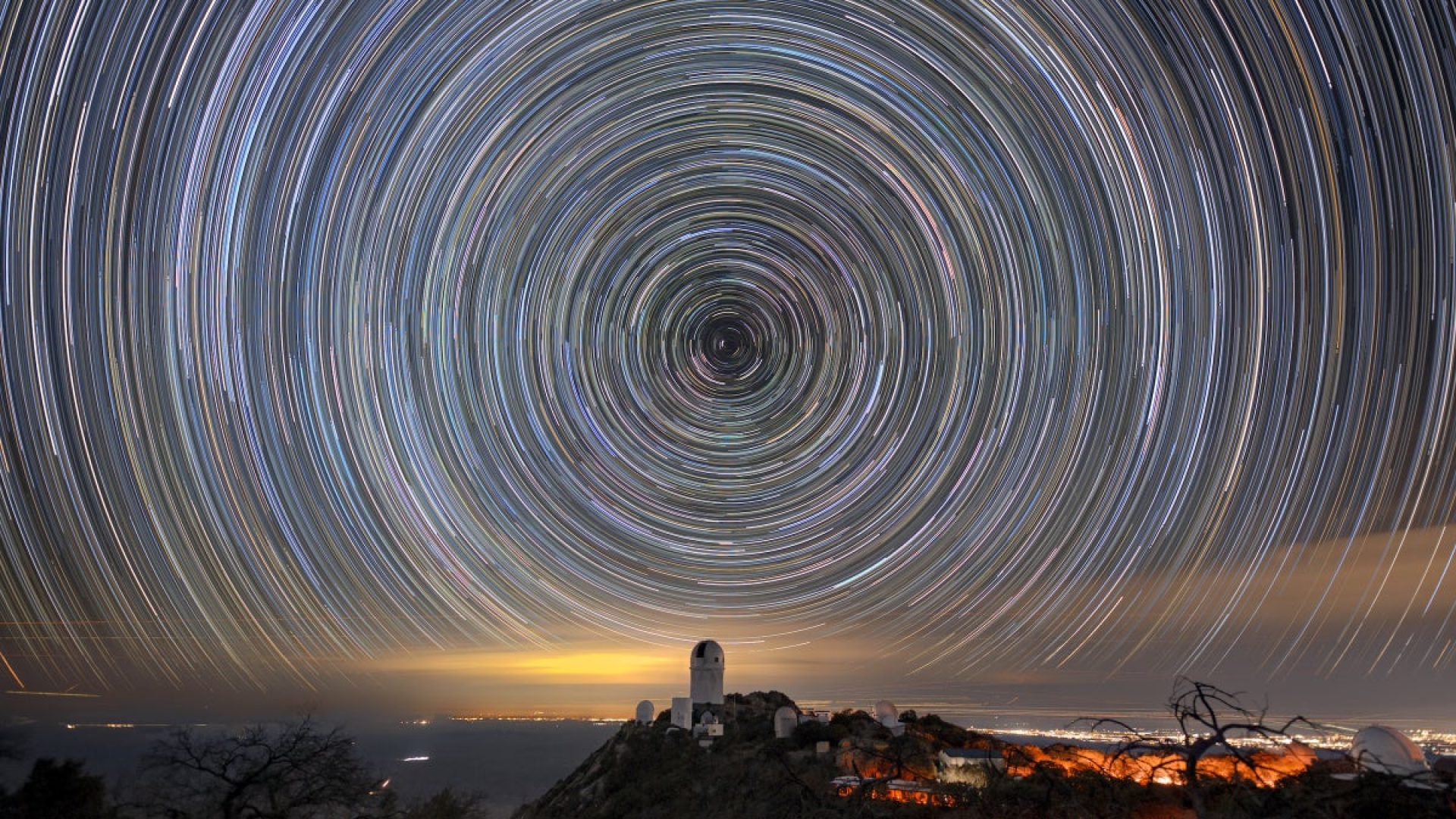 Star trails over the Mayall Telescope that houses DESI. Luke Tyas/Berkeley Lab and KPNO/NOIRLab/N...