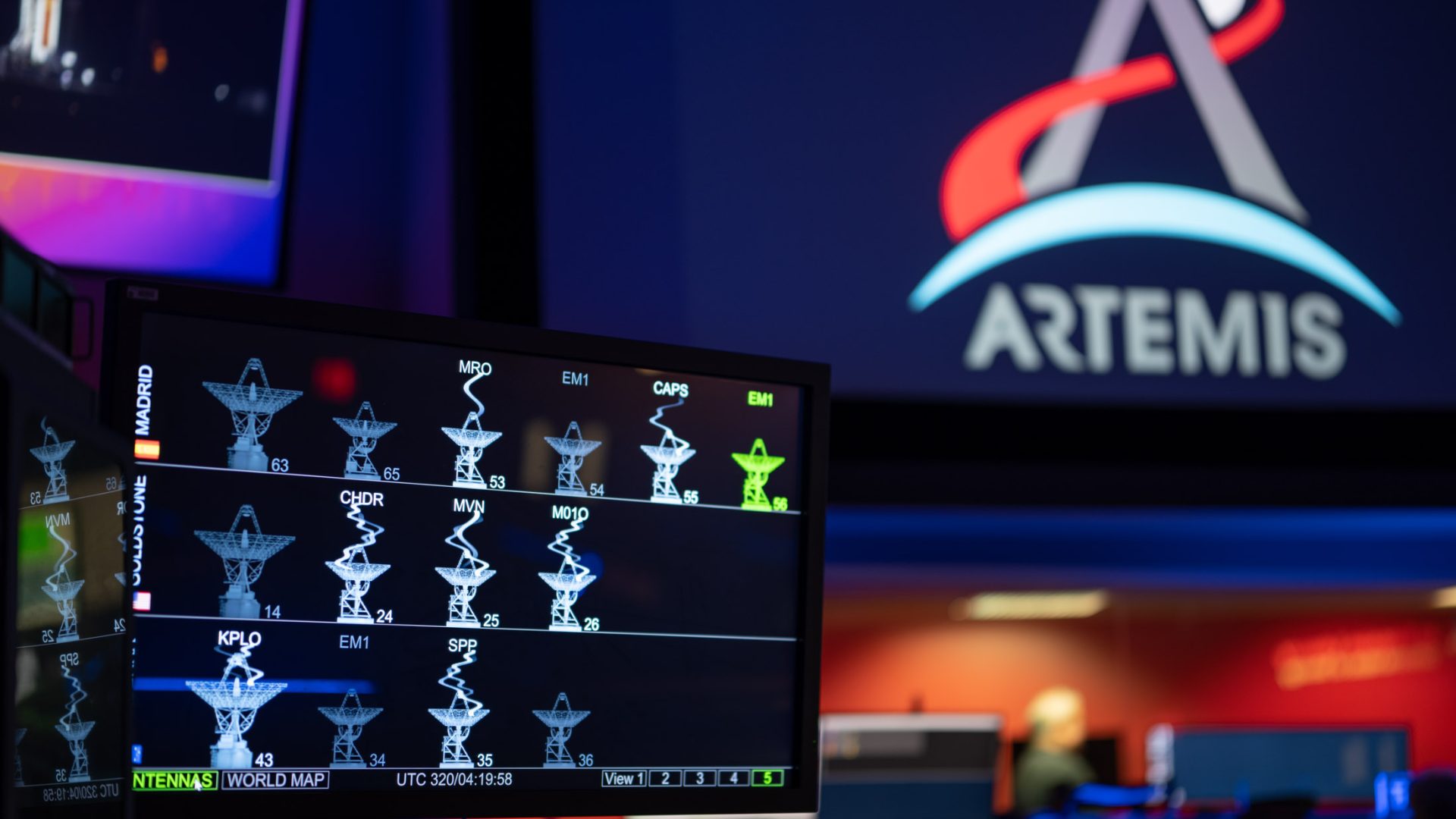 The DSN Now tool is displayed on a screen in the foreground—antenna images show real-time data ...