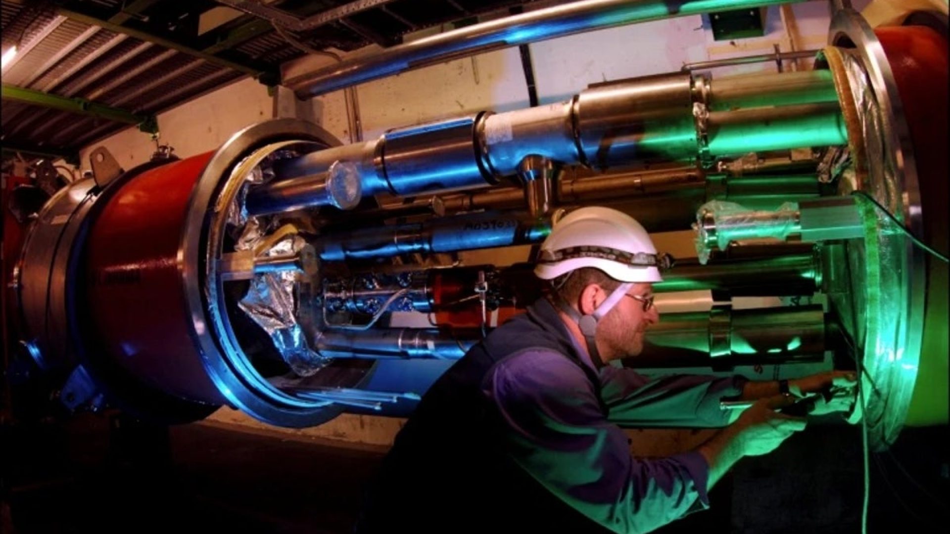 An engineer works on equipment for the LHCb experiment inside the tunnel of the Large Hadron Coll...