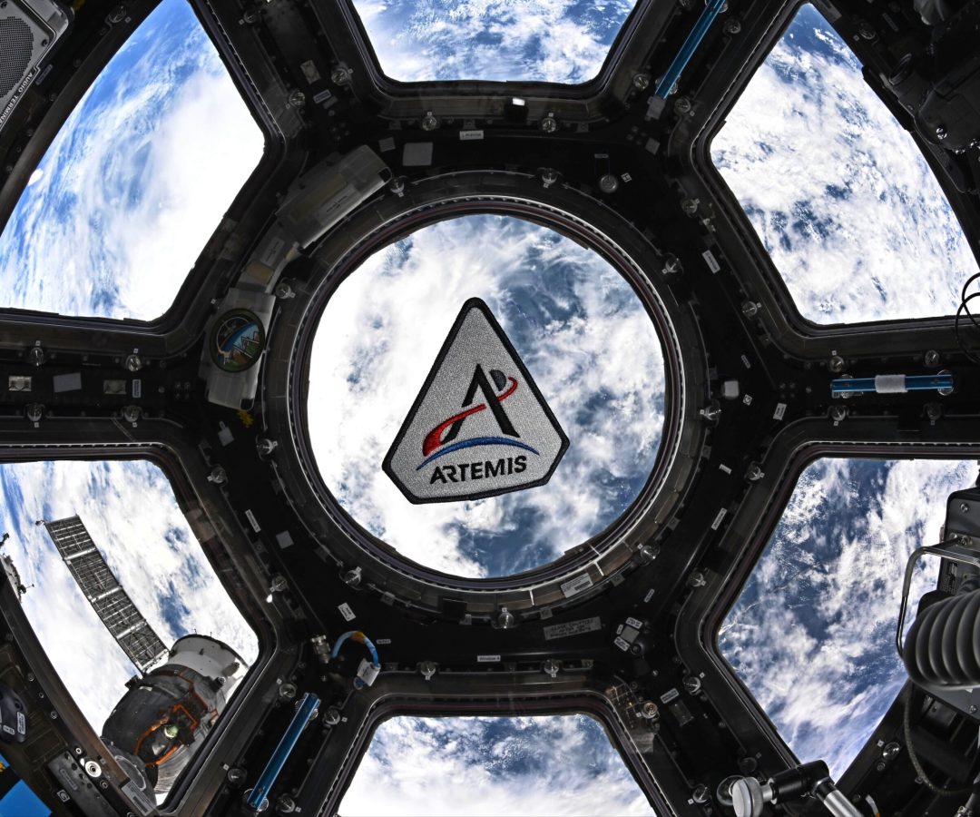 The Artemis program patch in the space station's cupola. The patch is framed by the center circul...