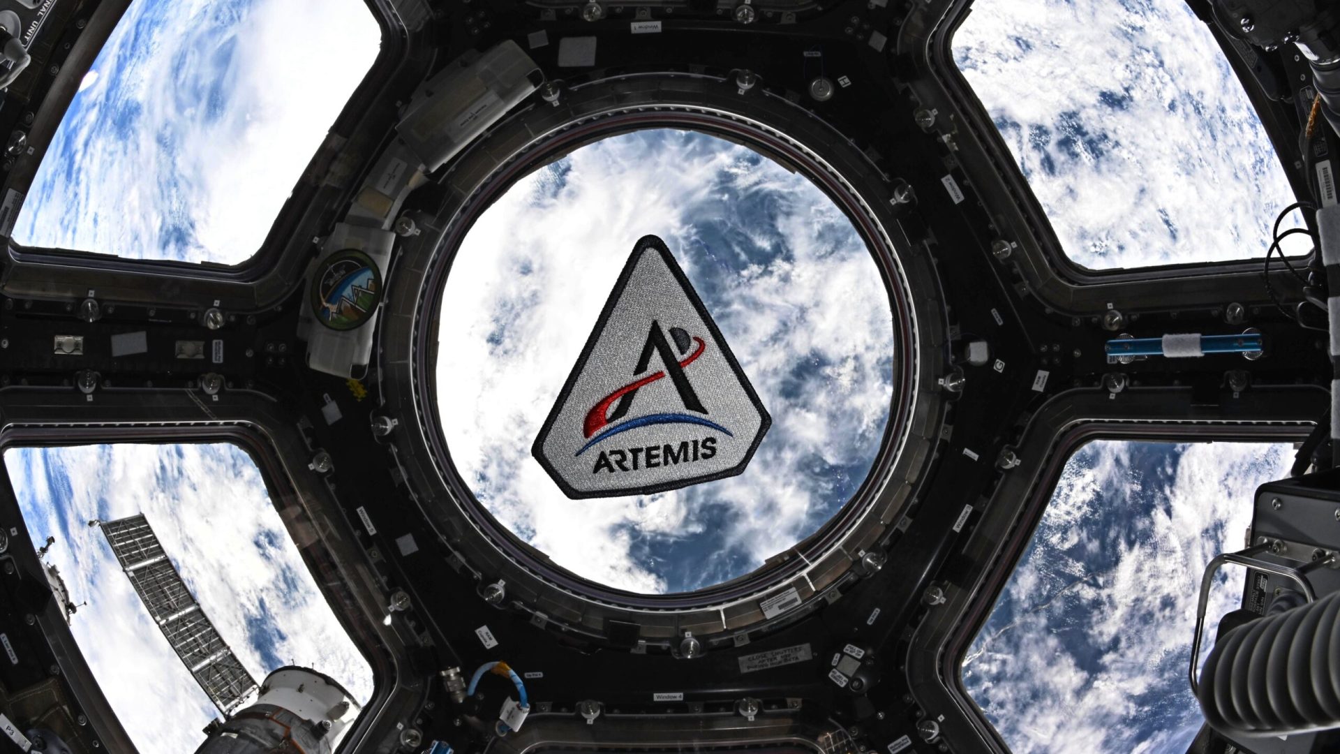 The Artemis program patch in the space station's cupola. The patch is framed by the center circul...