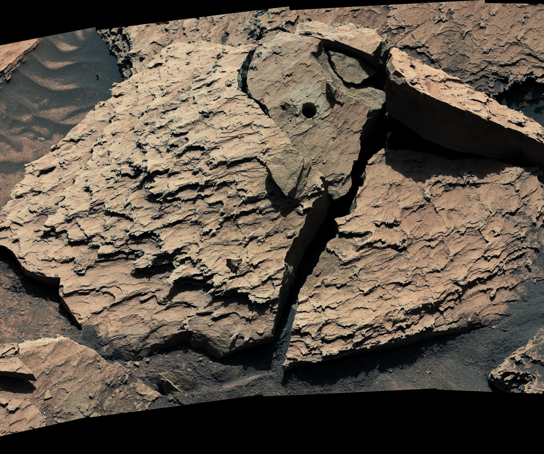 A large, reddish-brown rock as seen by NASA's Curiosity Mars rover. The rock is broken into sever...
